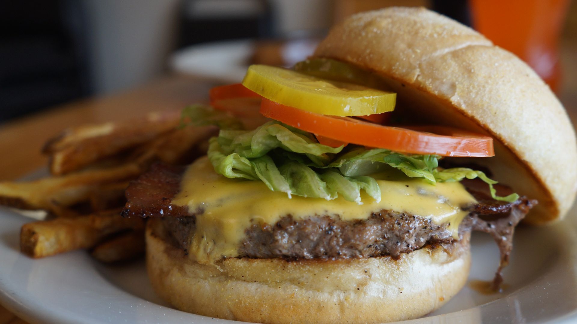 A close up of a hamburger and french fries on a plate.