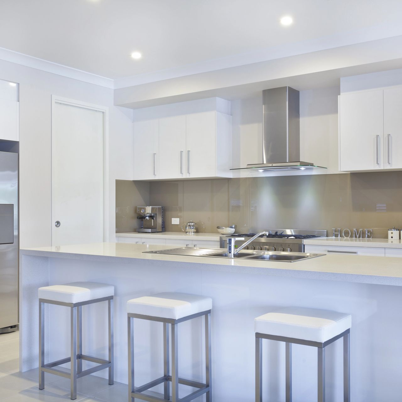 Cucina moderna con ripiani bianchi, mobili marroni e pensili azzurri.