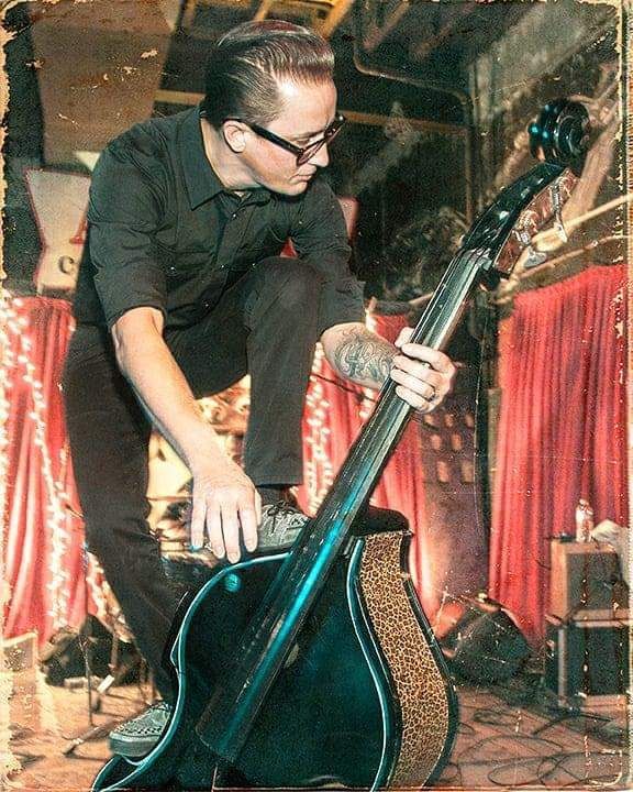 A man in a black shirt is playing a double bass