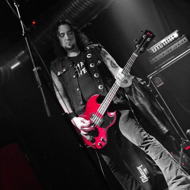 A man is playing a red gibson guitar