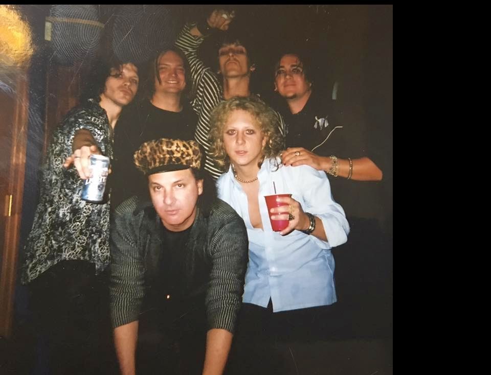 A group of people posing for a picture with one woman holding a red cup
