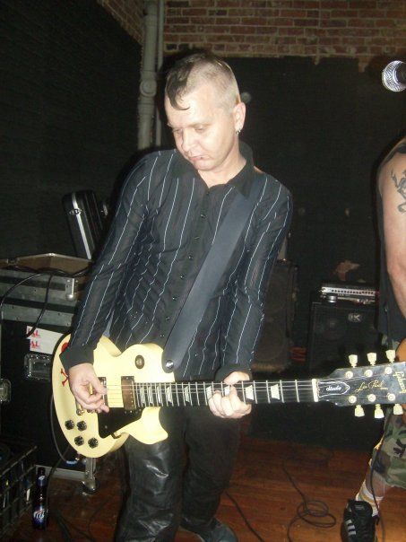 A man is playing a guitar in a dark room