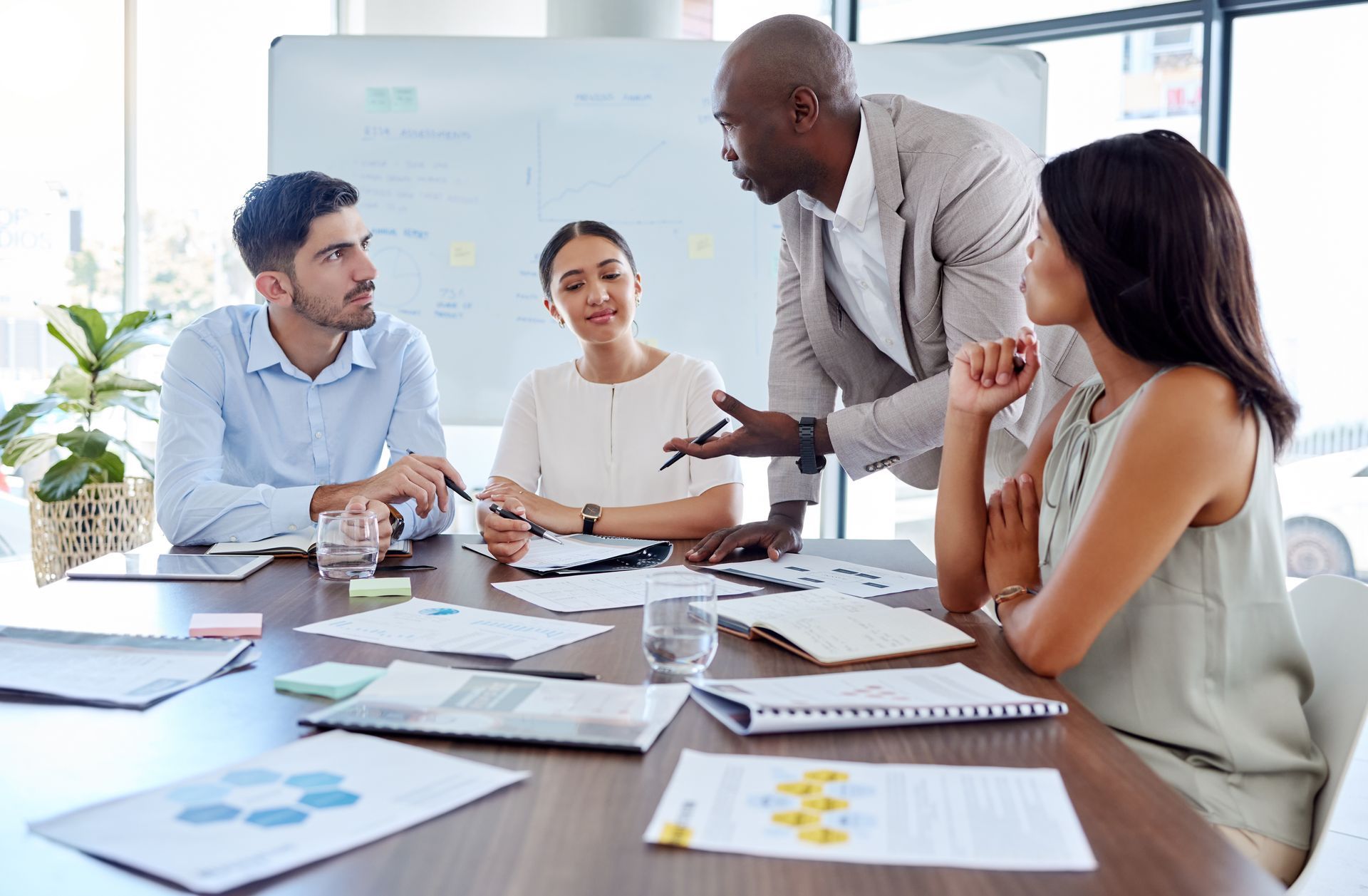 A group of people are sitting around a table having a meeting.