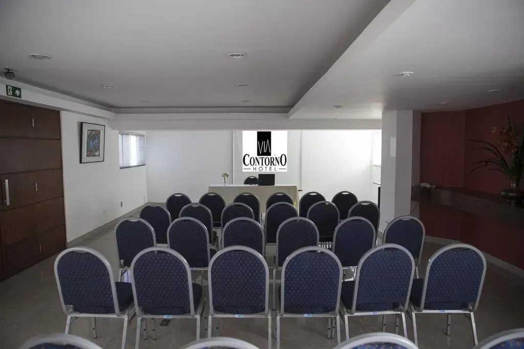 Uma sala de conferências com fileiras de cadeiras e uma placa que diz datall