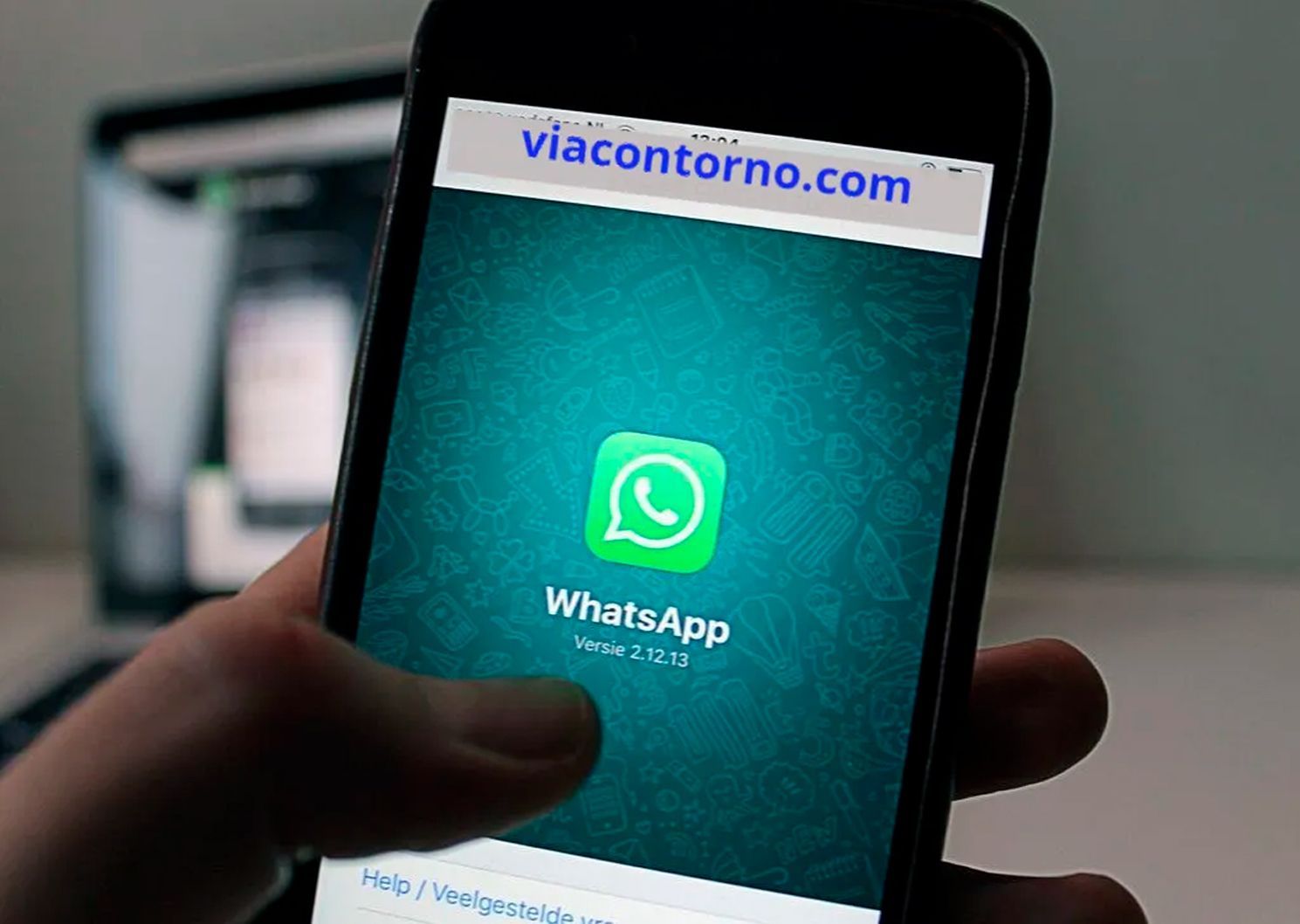 Uma pessoa está segurando um celular com o aplicativo whatsapp aberto
