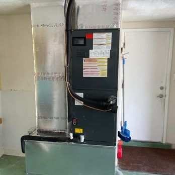 HVAC system with metal ductwork and control panel next to a white door.