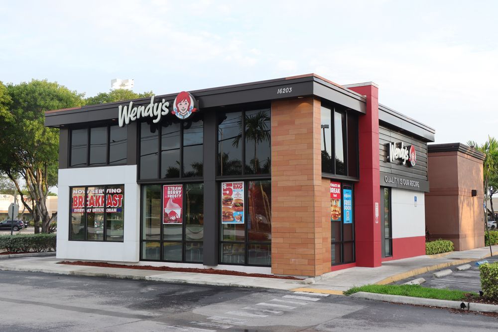 Wendy 's is a fast food restaurant located in a parking lot.