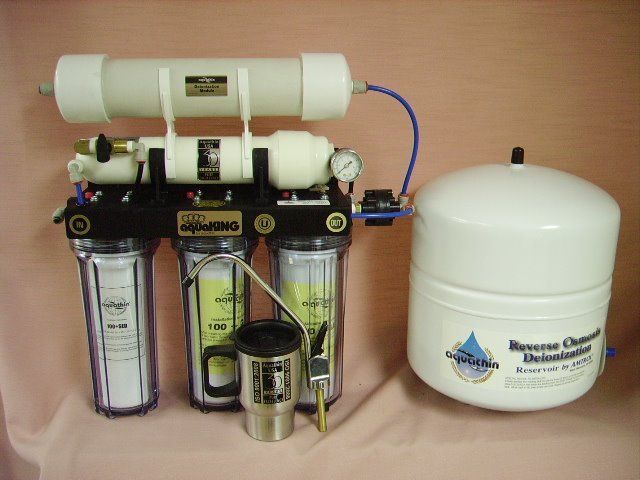 Reverse osmosis water filtration system with white and black components and storage tank.