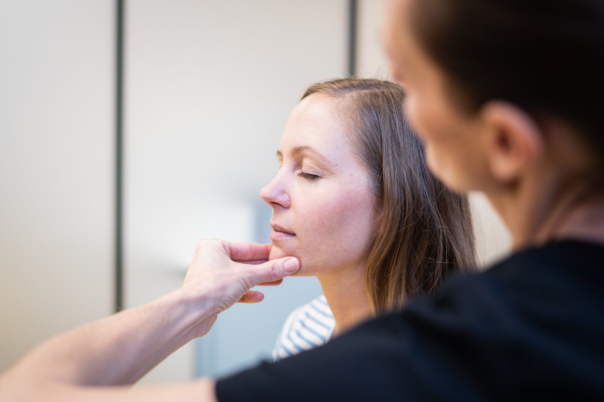 Eine Frau im schwarzen Tanktop bekommt Eine FrauNora Giger, MSPhTPhysiotherapie.