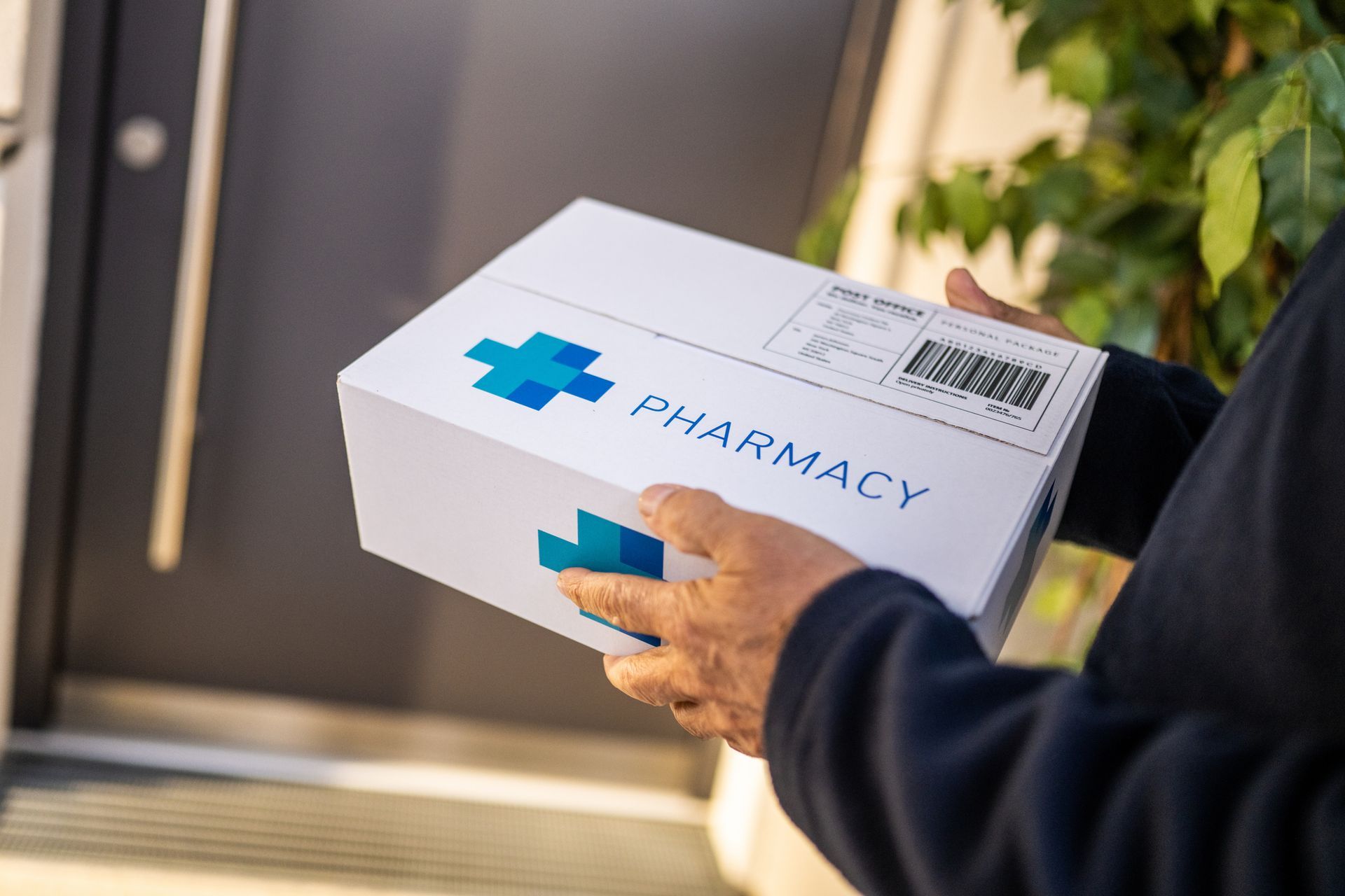 Close-up of delivery person with medicine package, showcasing pharmacy delivery services. Close-up of delivery person with medicine package, showcasing pharmacy delivery services.