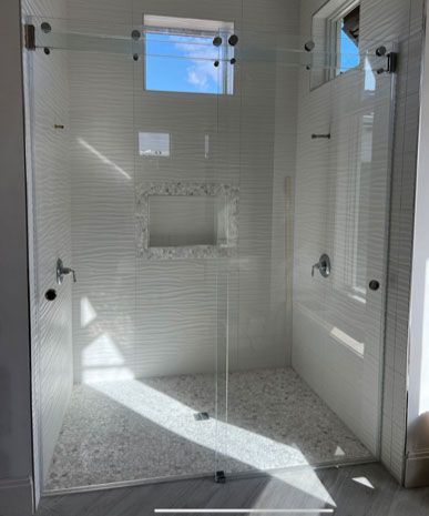 a bathroom with a sliding glass shower door and a window