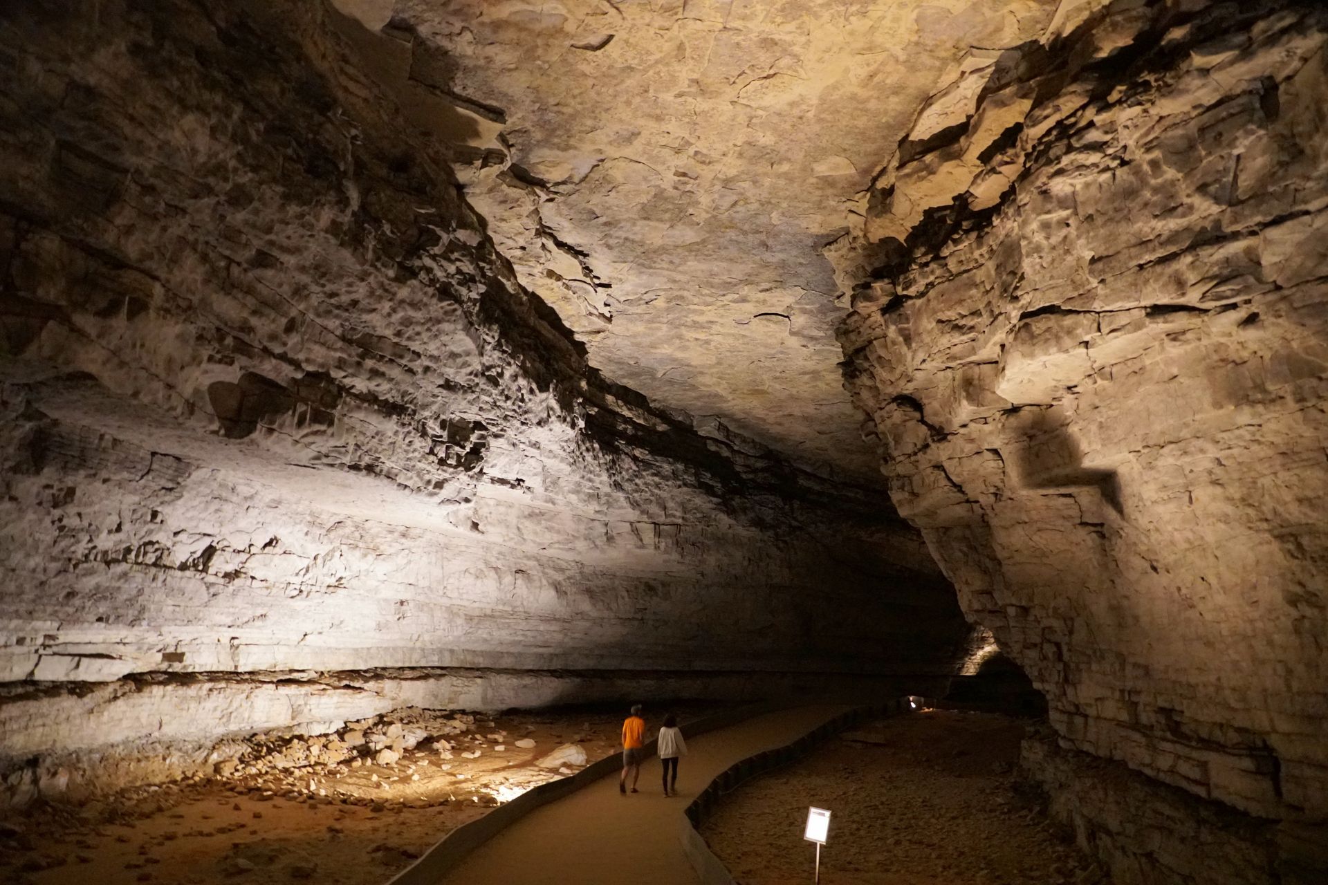 a group of people are walking through a cave .