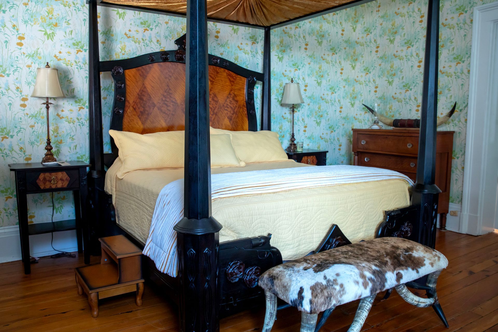 a bedroom with a four poster bed and a bench