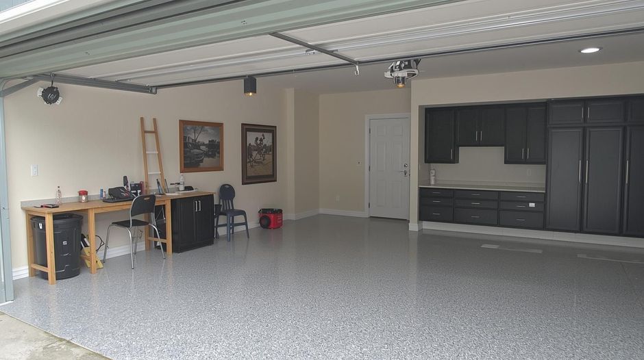 Bright white kitchen with island, stainless steel appliances, and hardwood floors.