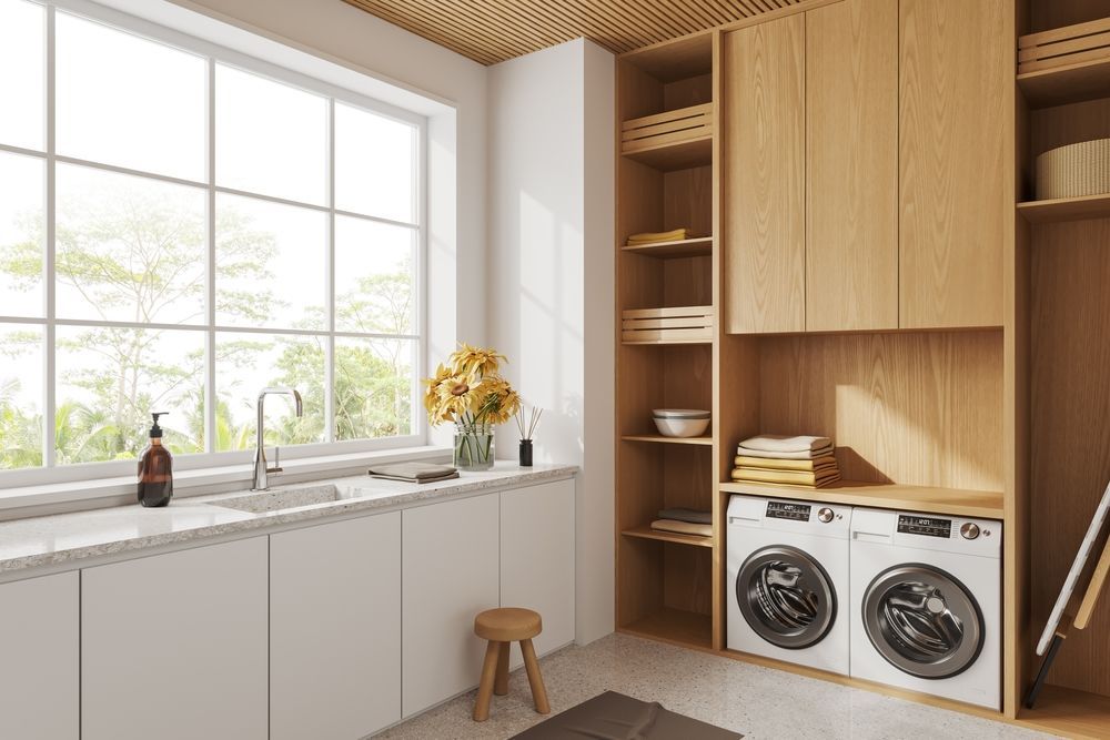 Laundry room with white cabinets, wood storage, washing machines, and window.