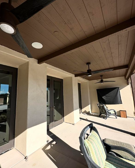 A patio with chairs and a ceiling fan