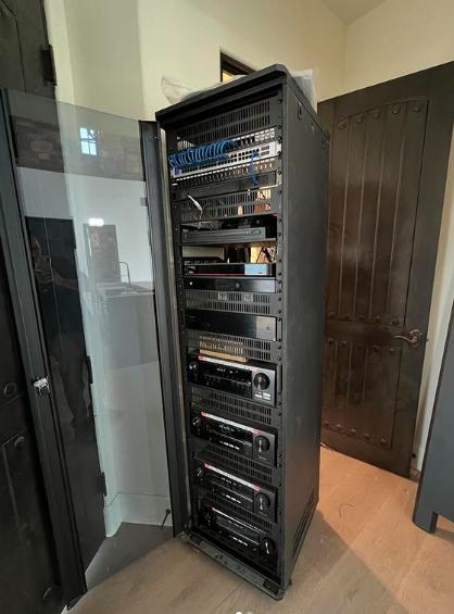 A server rack filled with lots of electronics in a room.
