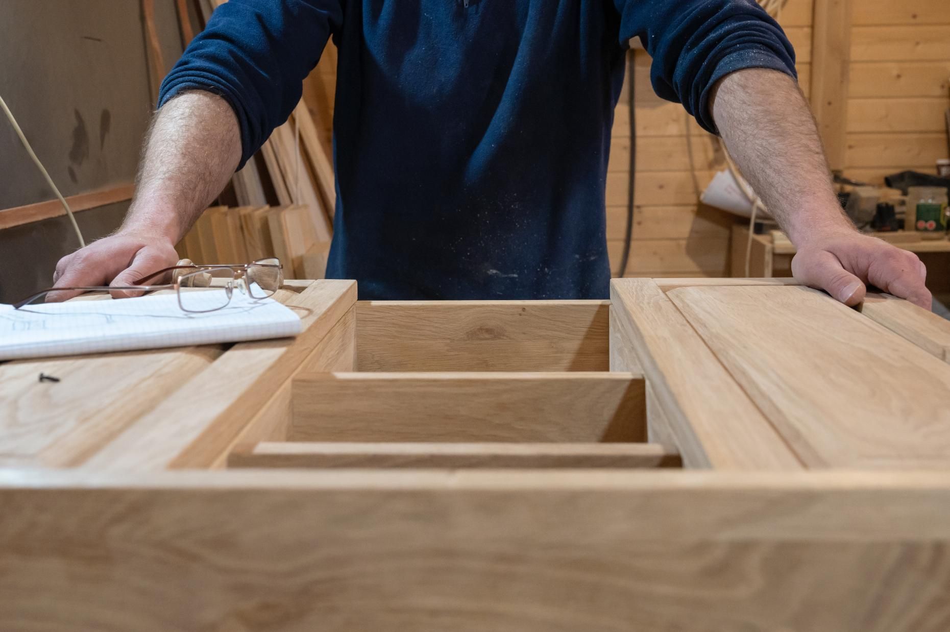 A man is working on a piece of wood in a workshop.