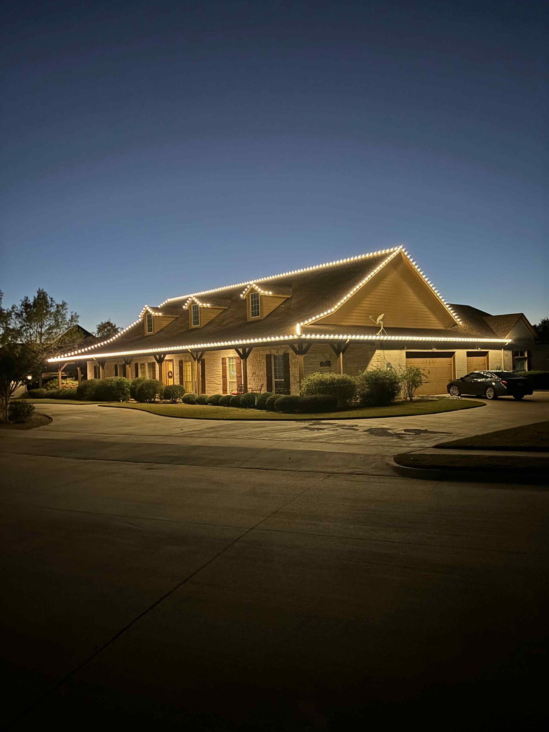A brick building lit with white lights at dusk.