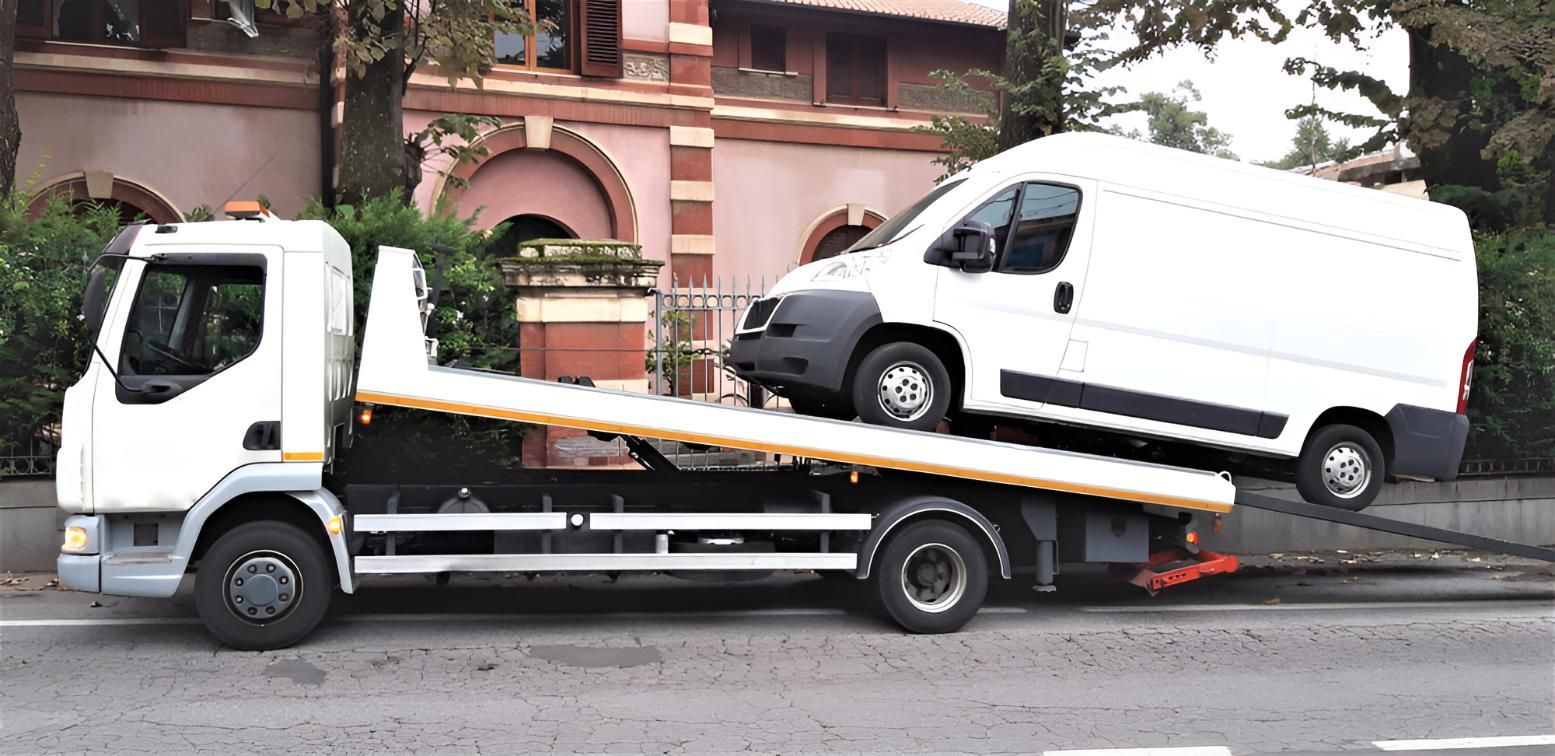 A Tow Truck With a White Van on Top of It — Airlie Towing & Tilt Tray Hire In Cannonvale, QLD