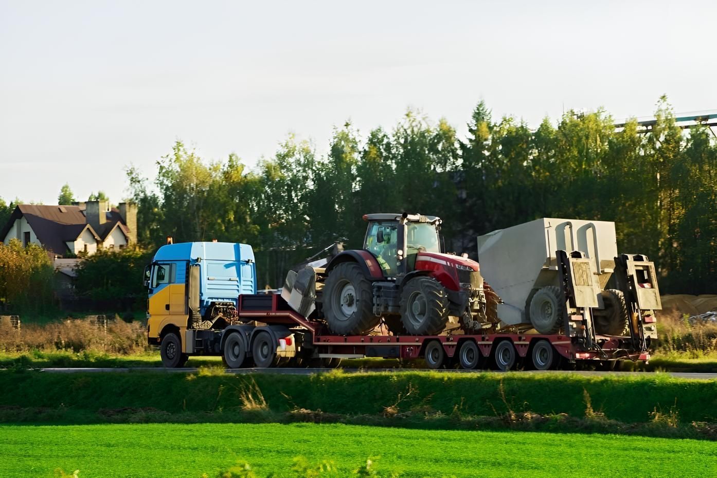A Semi Truck is Carrying a Tractor on a Trailer — Airlie Towing & Tilt Tray Hire In Cannonvale, QLD