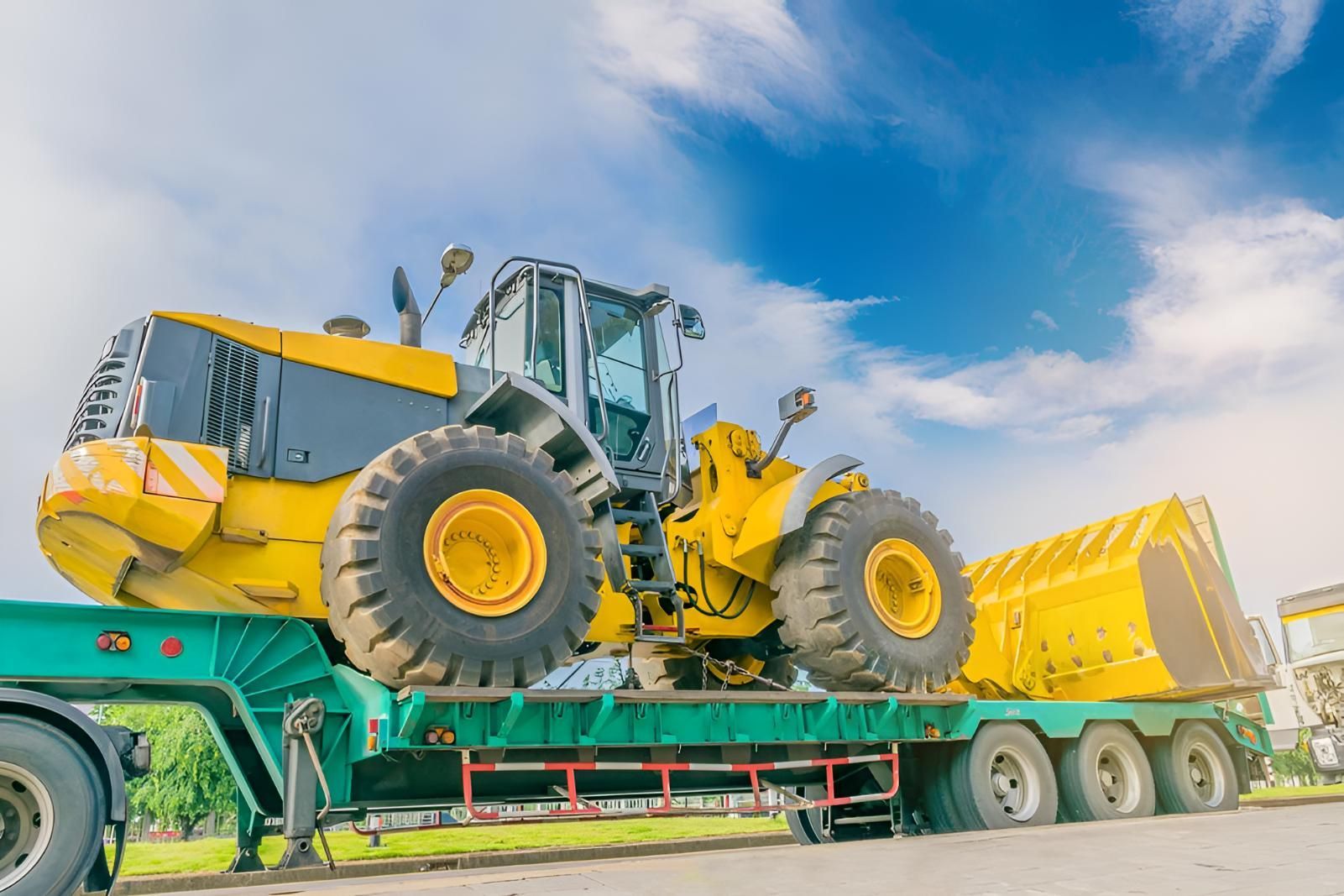 A Yellow Bulldozer is Sitting on Top of a Green Trailer — Airlie Towing & Tilt Tray Hire In Cannonvale, QLD
