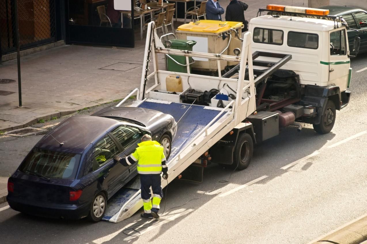 A Tow Truck is Towing a Car on the Side of the Road — Airlie Towing & Tilt Tray Hire In Cannonvale, QLD