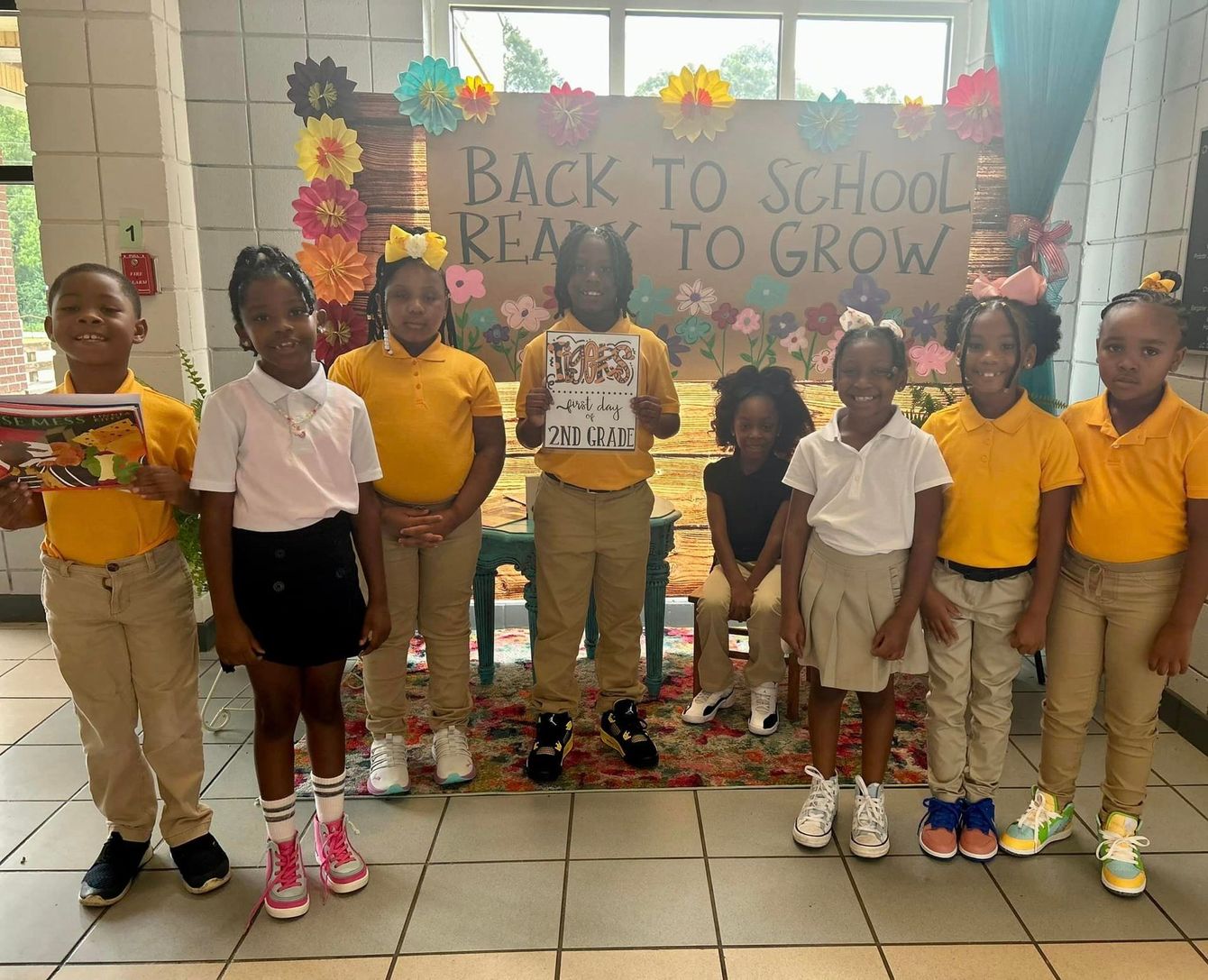 a group of children are standing in front of a sign that says back to school ready to grow
