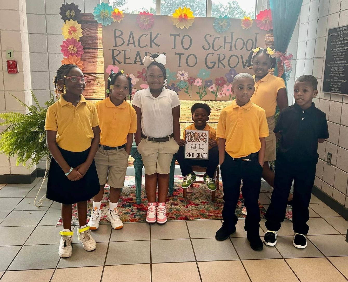 a group of children standing in front of a sign that says back to school