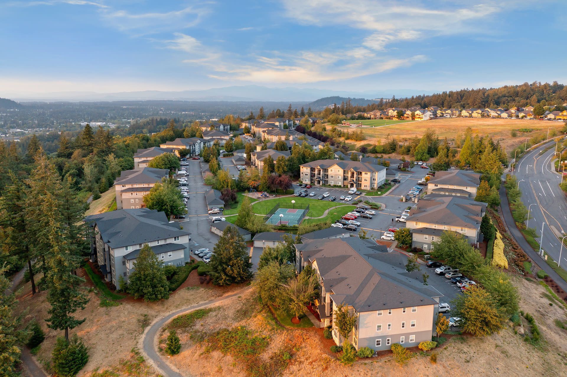 Aerial view of a multifamily apartment community with buildings, parking, and green spaces.