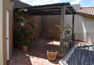 A patio with a pergola and potted plants