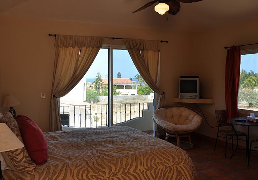 A bedroom with a bed , chair , table and television.