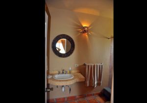A bathroom with a sink , mirror and towel rack.