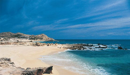 A beach with a lot of rocks and waves coming in