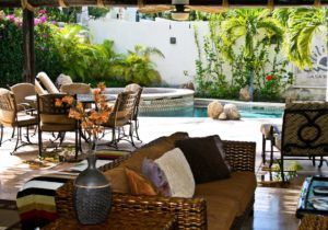 A living room with a couch and chairs and a pool in the background