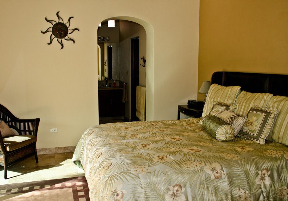 A bedroom with a king size bed and a chair