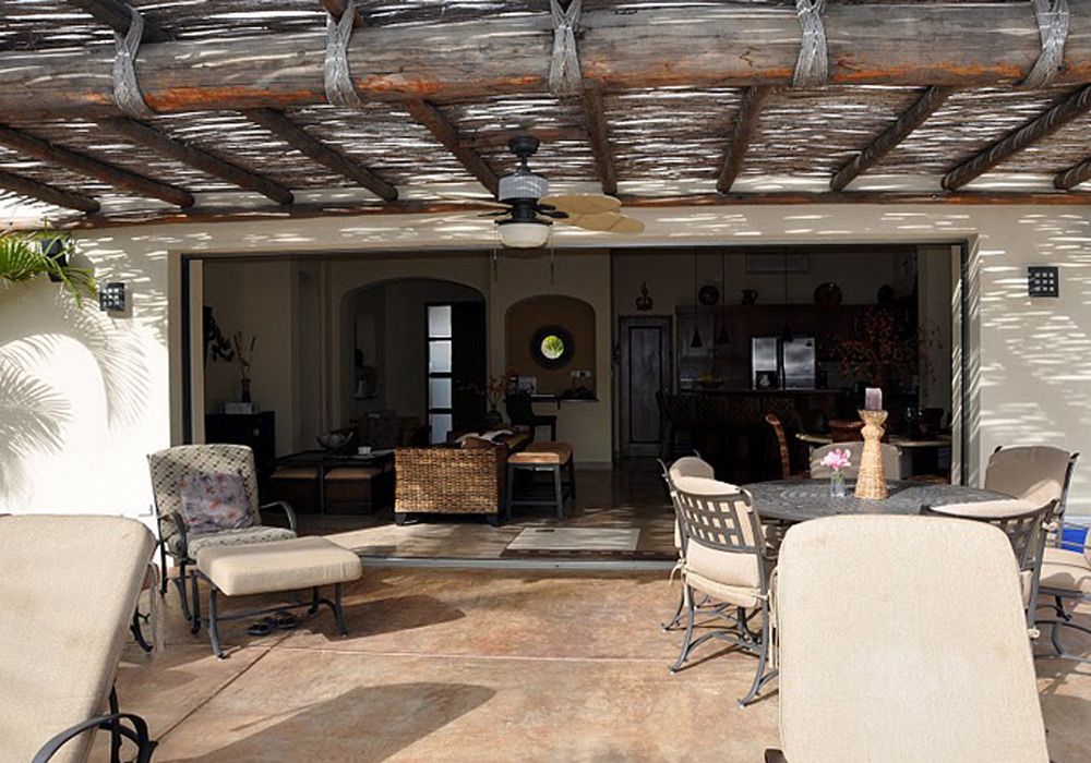 A patio with tables and chairs and a ceiling fan