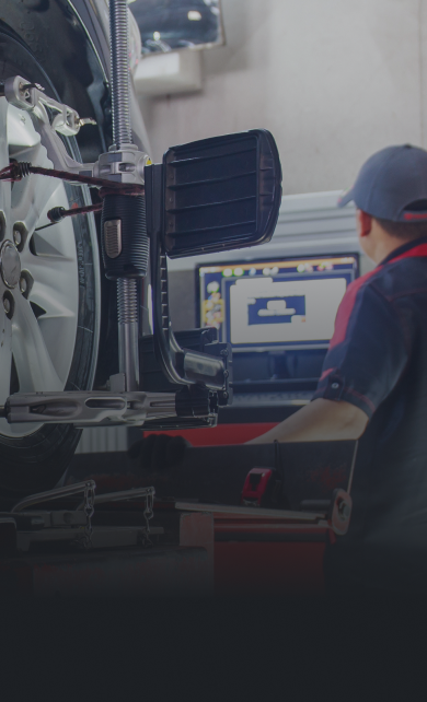 Mechanic performing wheel alignment on a car using a computer in a garage. | Zee's Alignment & Autocare