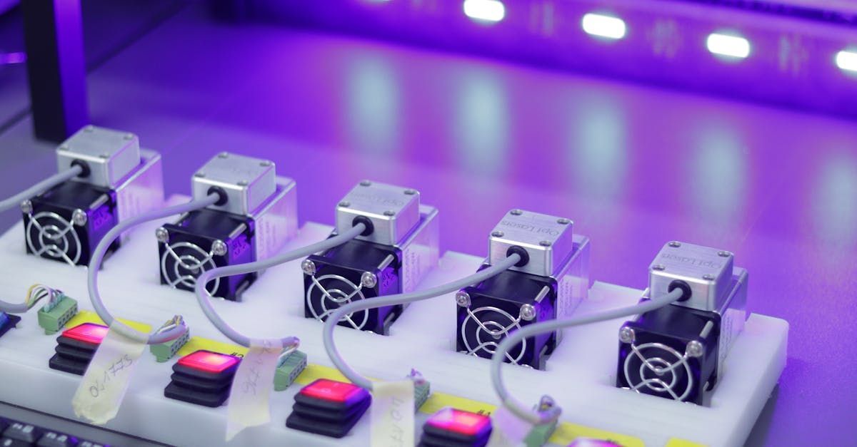 A bunch of electronics are sitting on top of a table with purple lights behind them.