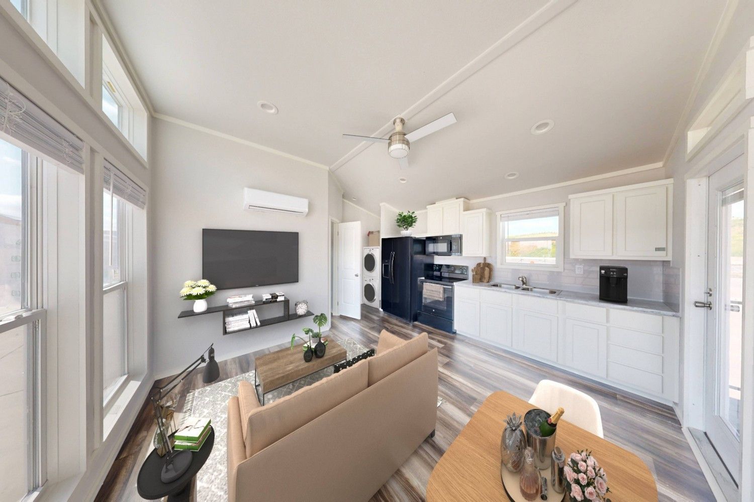 Interior view of a modern small house with living room, kitchen, and dining area. Neutral colors with natural light.