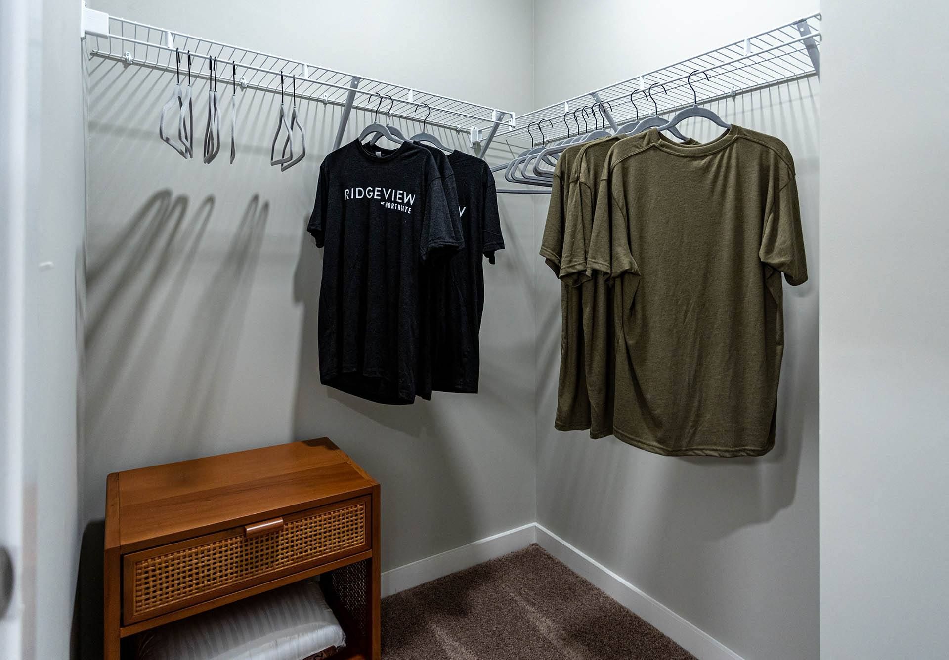 a walk in closet with a wooden dresser