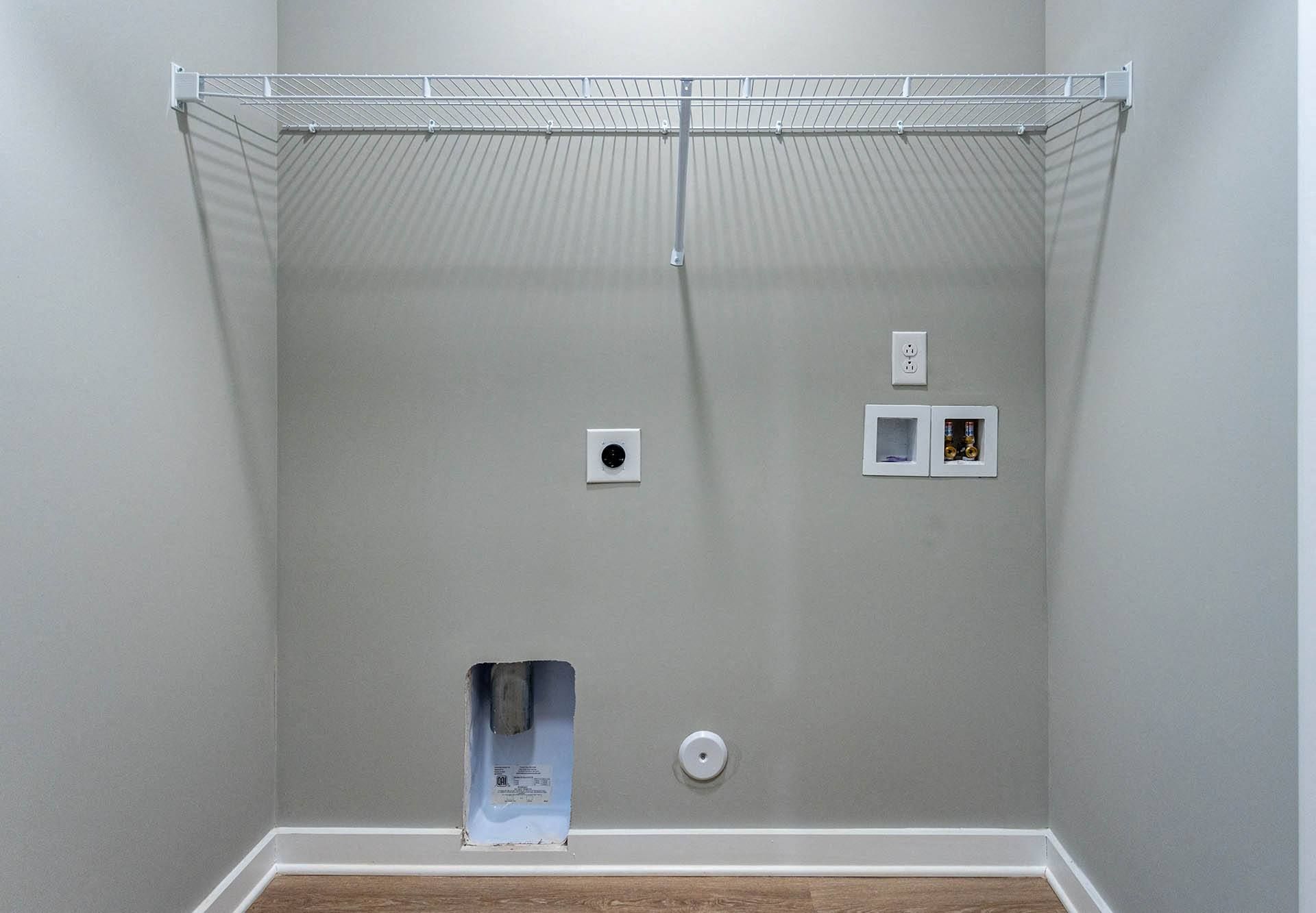 a closet with a wire shelving unit on top of it and a toilet paper dispenser