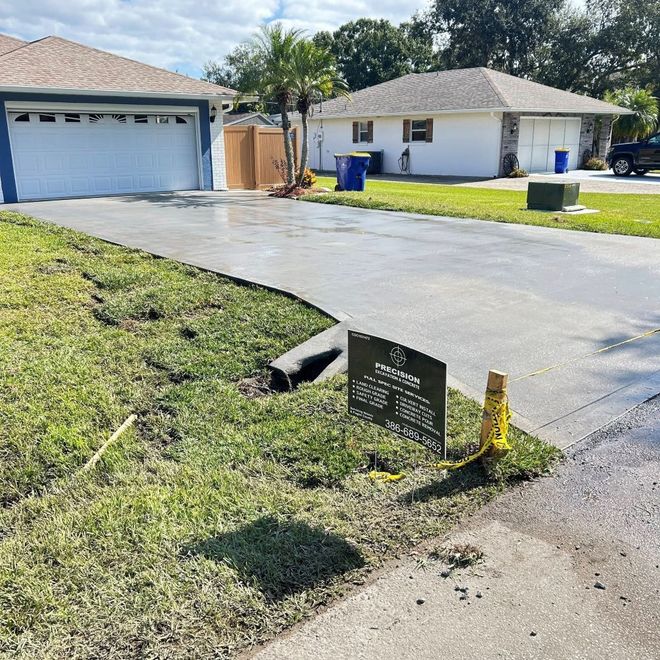 Driveway and lawn in front of two houses, with construction sign and yellow caution tape.