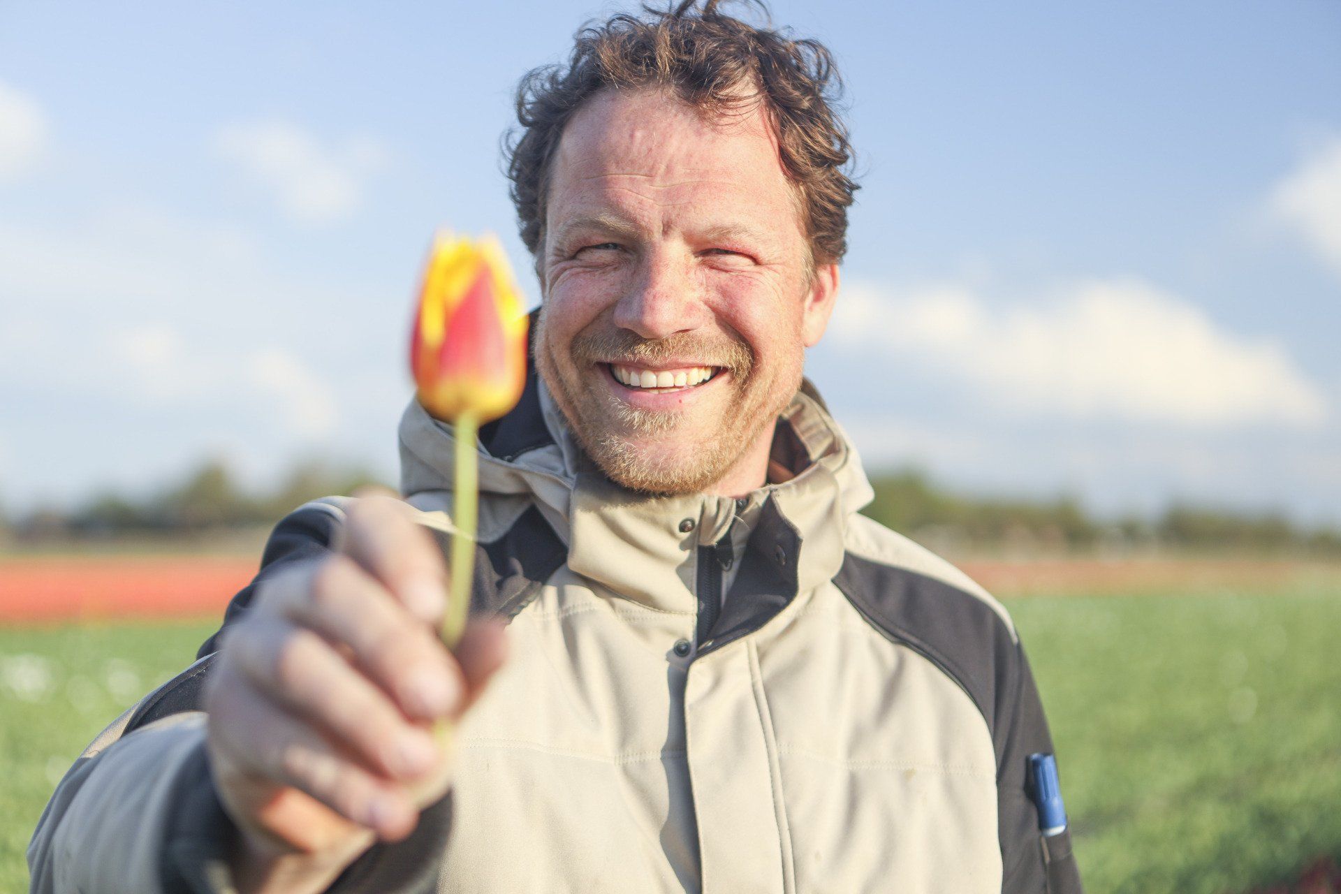 Christian Kolk, een fervente tulpenveredelaar, houdt de tulp Dr. Nicholaes van het Amsterdam UMC vast.
