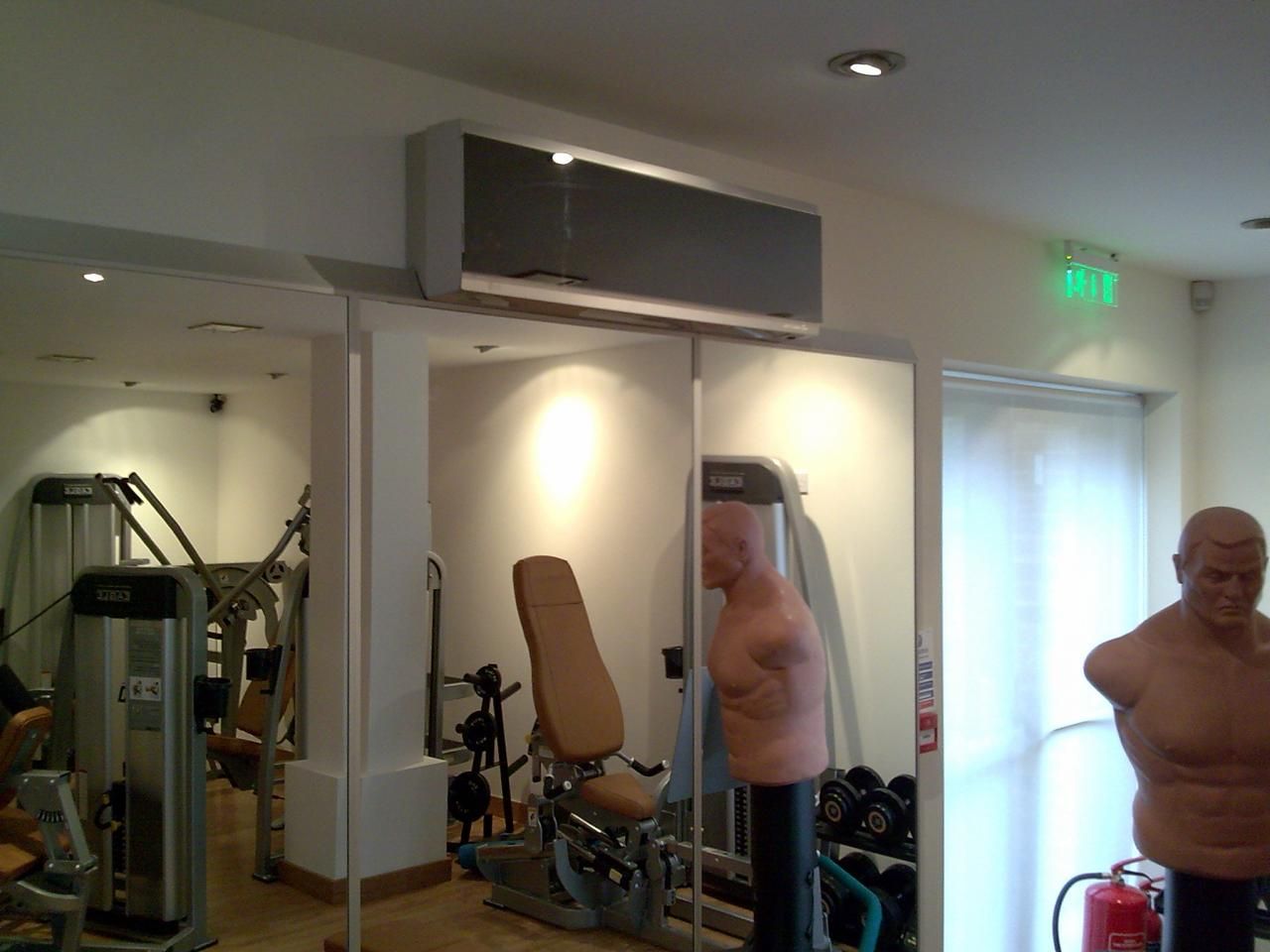 A gym with a green exit sign on the wall