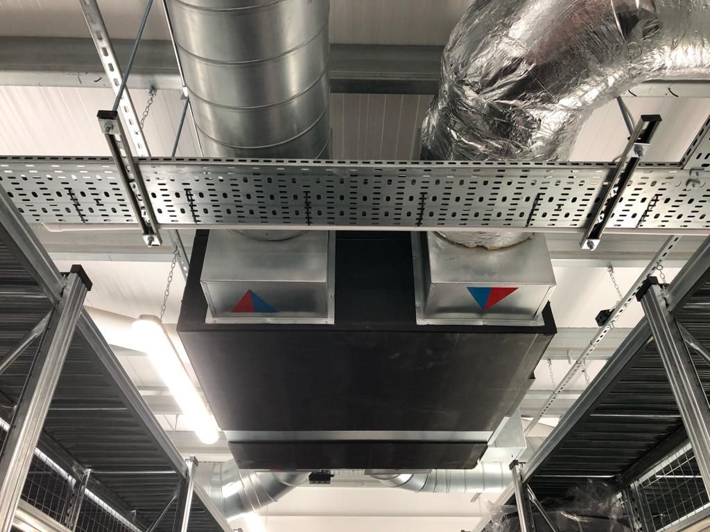 A large air conditioner is hanging from the ceiling of a building.