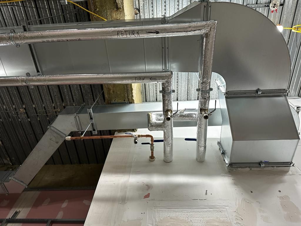 A large metal pipe is hanging from the ceiling of a building.