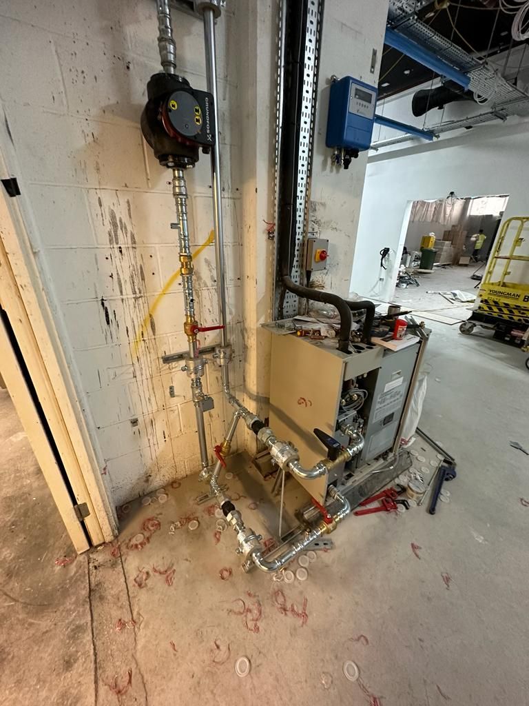 A room with a lot of pipes and wires on the floor.