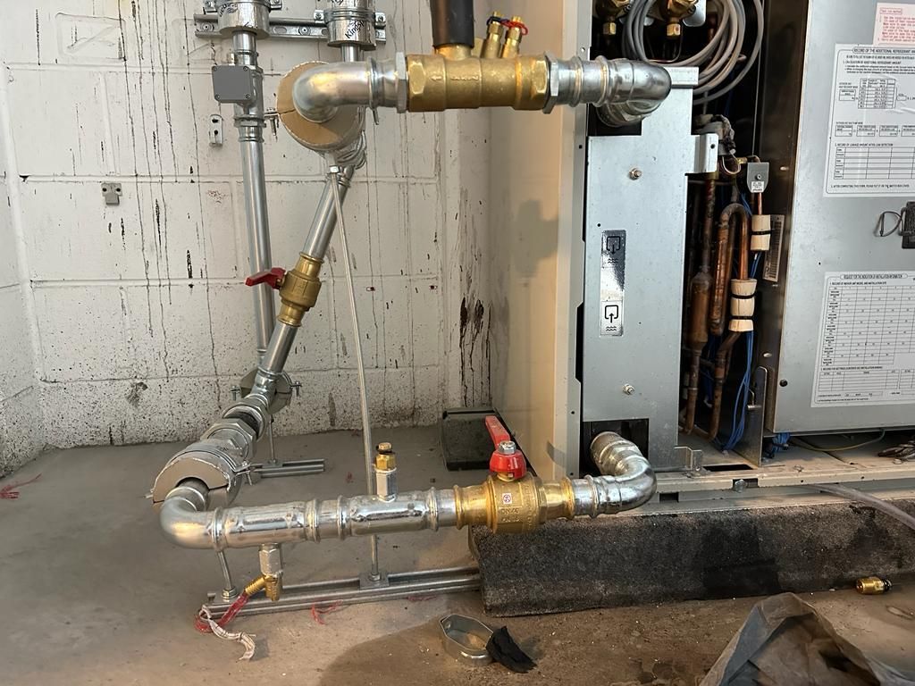 A bunch of pipes are connected to a machine in a room.