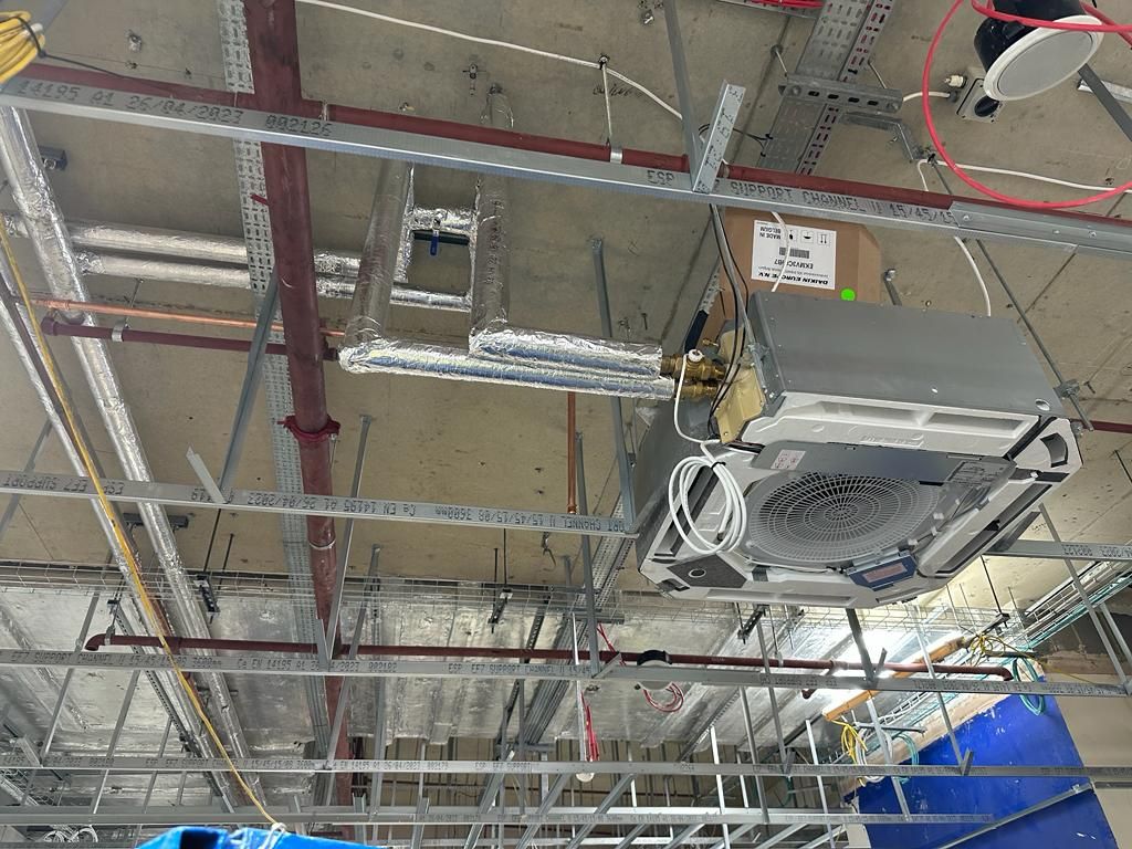 A fan is hanging from the ceiling of a building under construction.